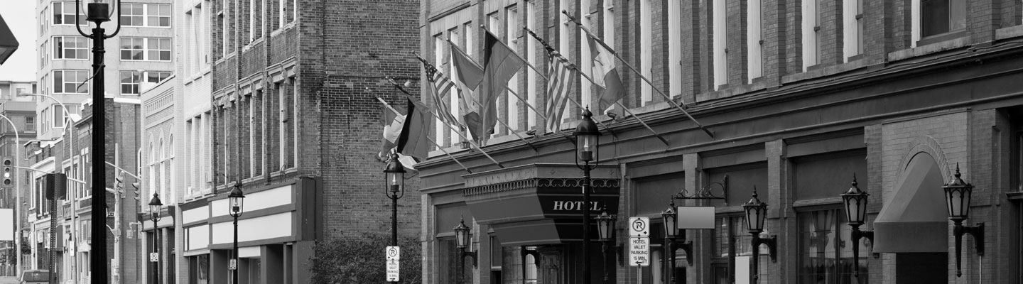 Old brick architectural building in Kitchener with flags of different nationalities protruding from it