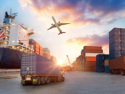 cargo ship, shipping containers and trucks with airplane flyer overhead